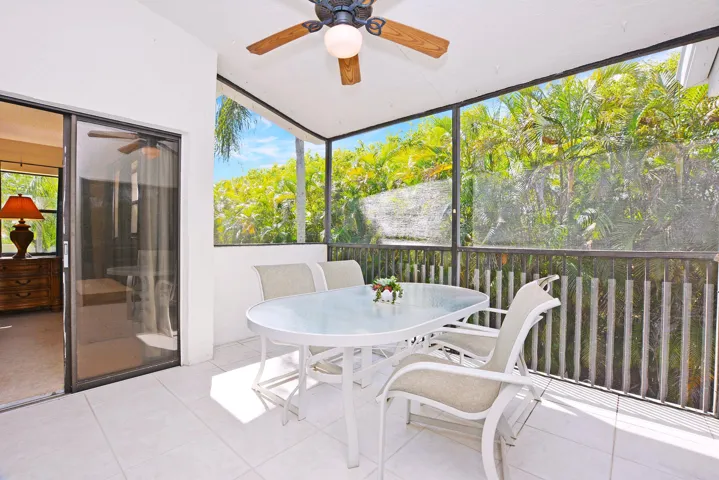 Oversized tiled screened porch with lots of lush landscaping abutting Quail Ridge Country Club.