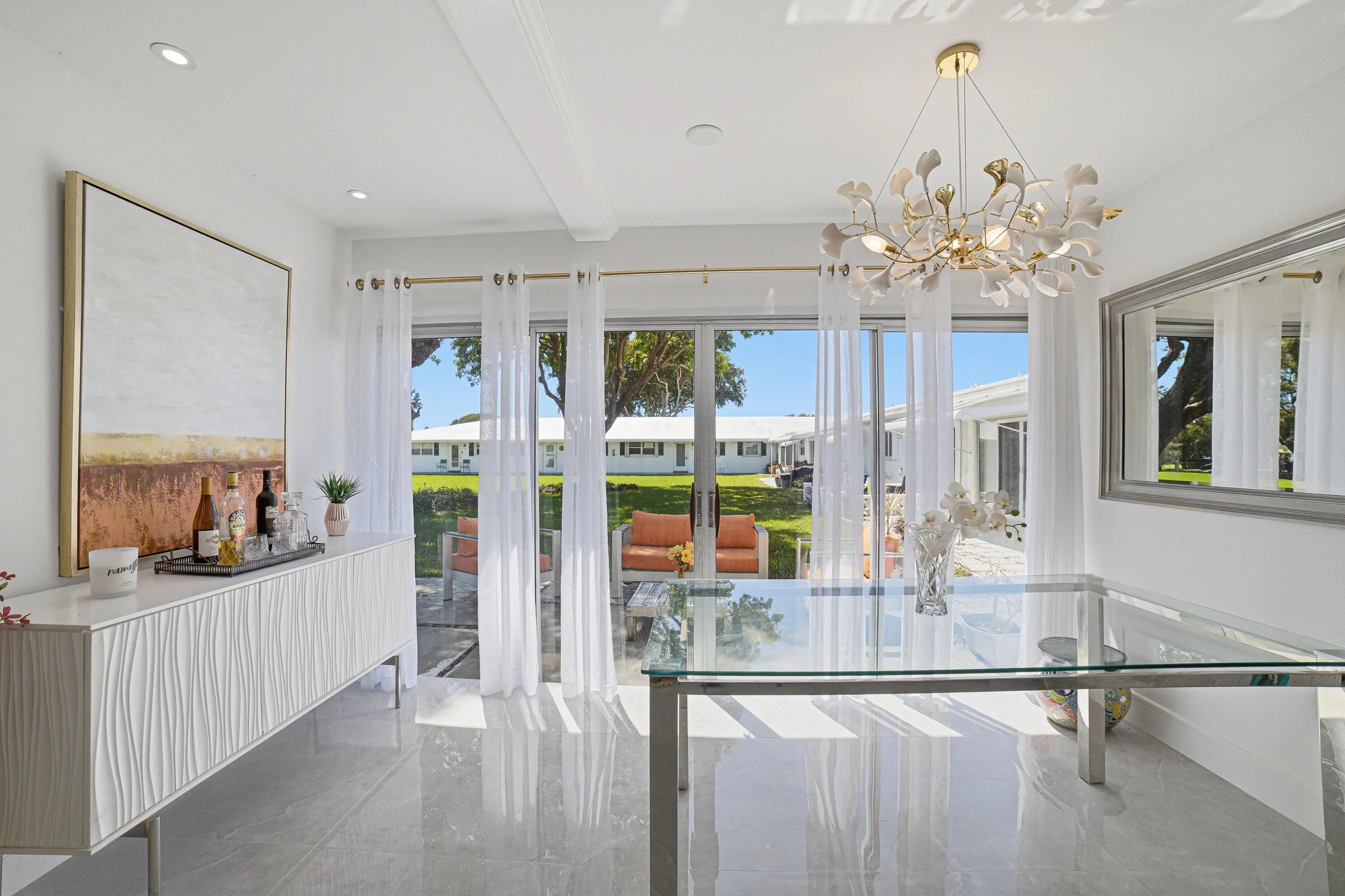 A designer chandelier embellishes the coffered ceiling and engulfs the dining area with a romantic light