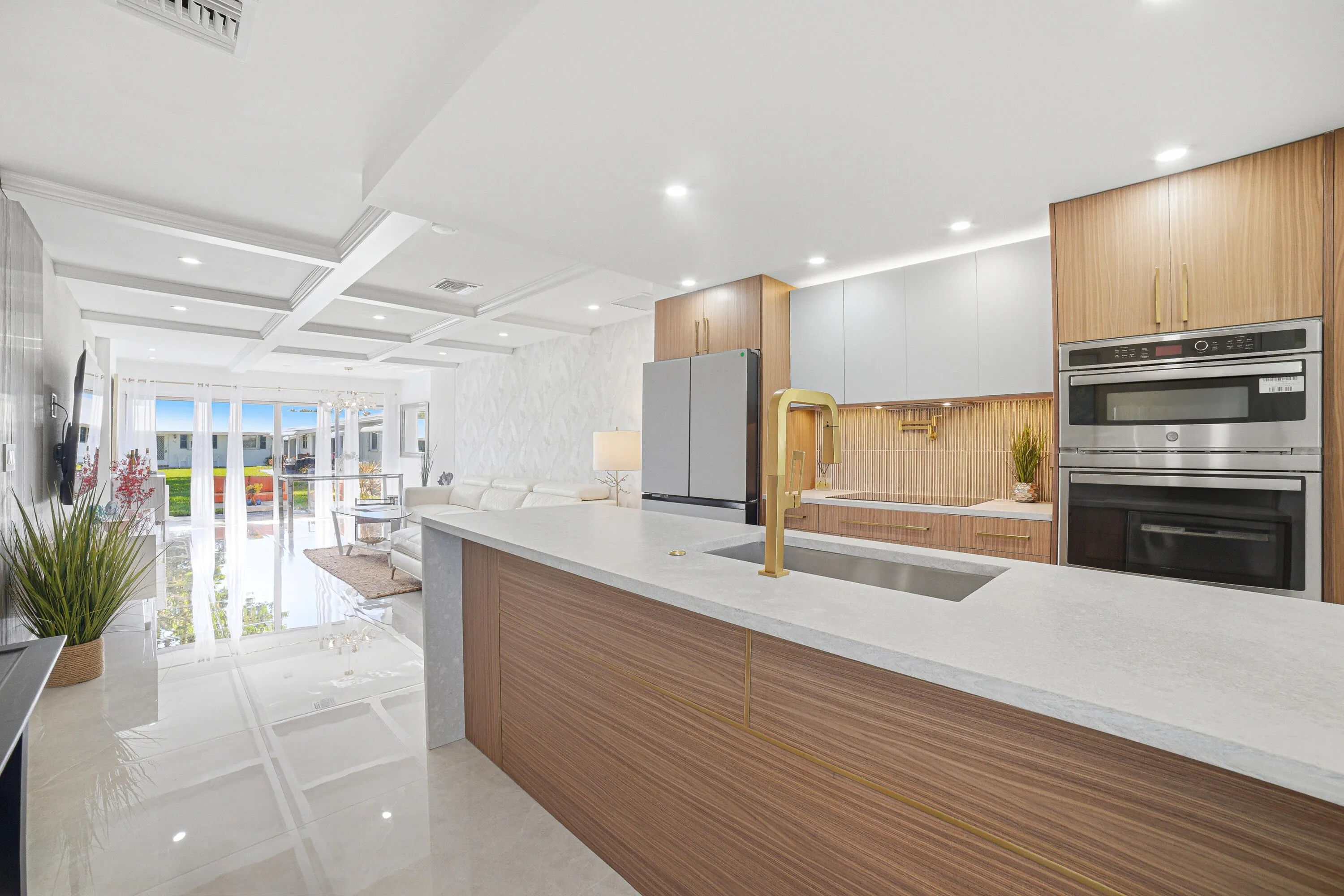 The kitchen features European-style cabinets with soft touch closures for smooth operation. It includes a dual wall oven/microwave combo and a pot filler faucet, blending practicality with elegant design.