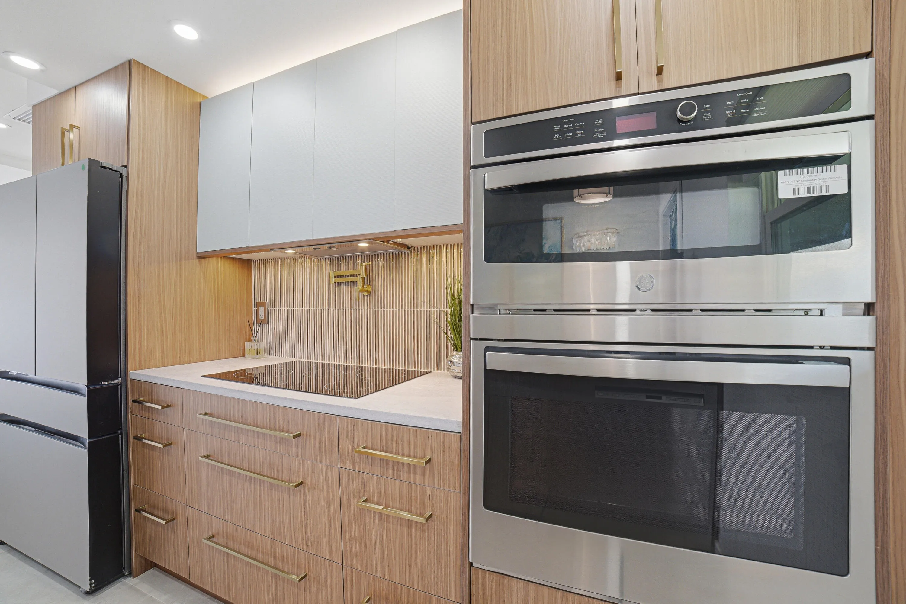 Details of wall dual oven/microwave to the right of the top electric stove. Above the stove notice the pot filler