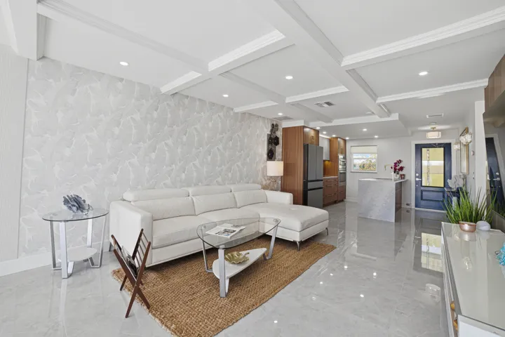 The exquisite tone-on-tone wallpaper with an accent design of large leaves creates an accent wall behind the couch.