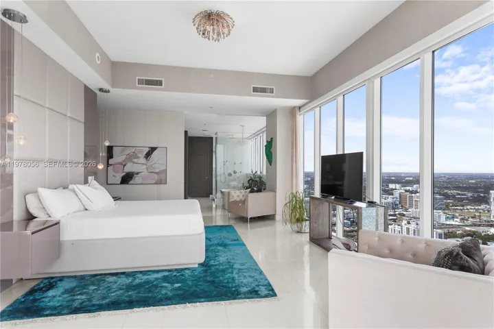 Primary bedroom with floor-to-ceiling glass walls