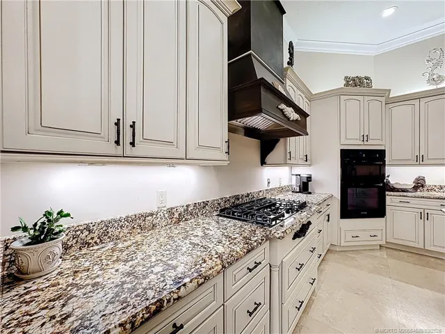 ALL GRANITE COUNTER AND GAS STOVE 5 BURNERS VENTS OUT. BUILD IN OVEN AND MIROWAVE WITH CONFECTION. LOTS AND LOTS OF CABINETS. WINE COOLER WITH EXTRA ICE MAKER, AND WINE COOLER. CROWN MOLDING. ROOM TO ROAM WITH DOUBLE SINK AREAS WITH 2 ISLANDS,