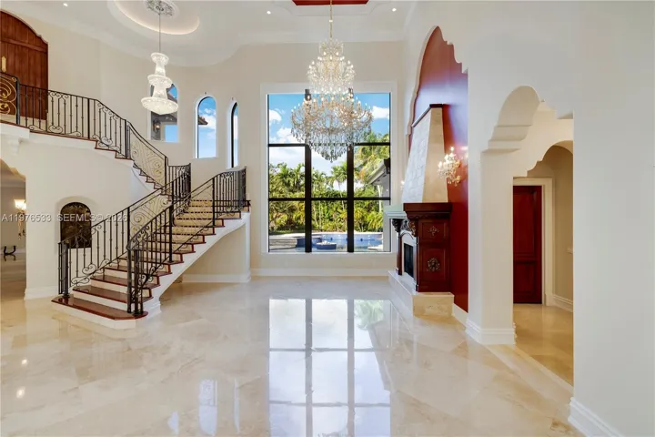 Grand double-height entry with soaring ceilings and a stunning view of the pool, creating an impressive and light-filled welcome.