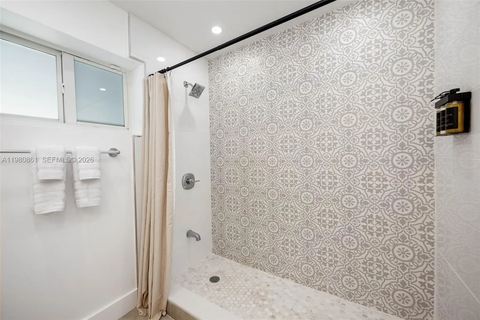 to Master Bedroom with striking spa-inspired shower featuring designer patterned tile, refined fixtures, and a serene, light-filled ambiance—delivering a sophisticated, resort-quality bathing experience.