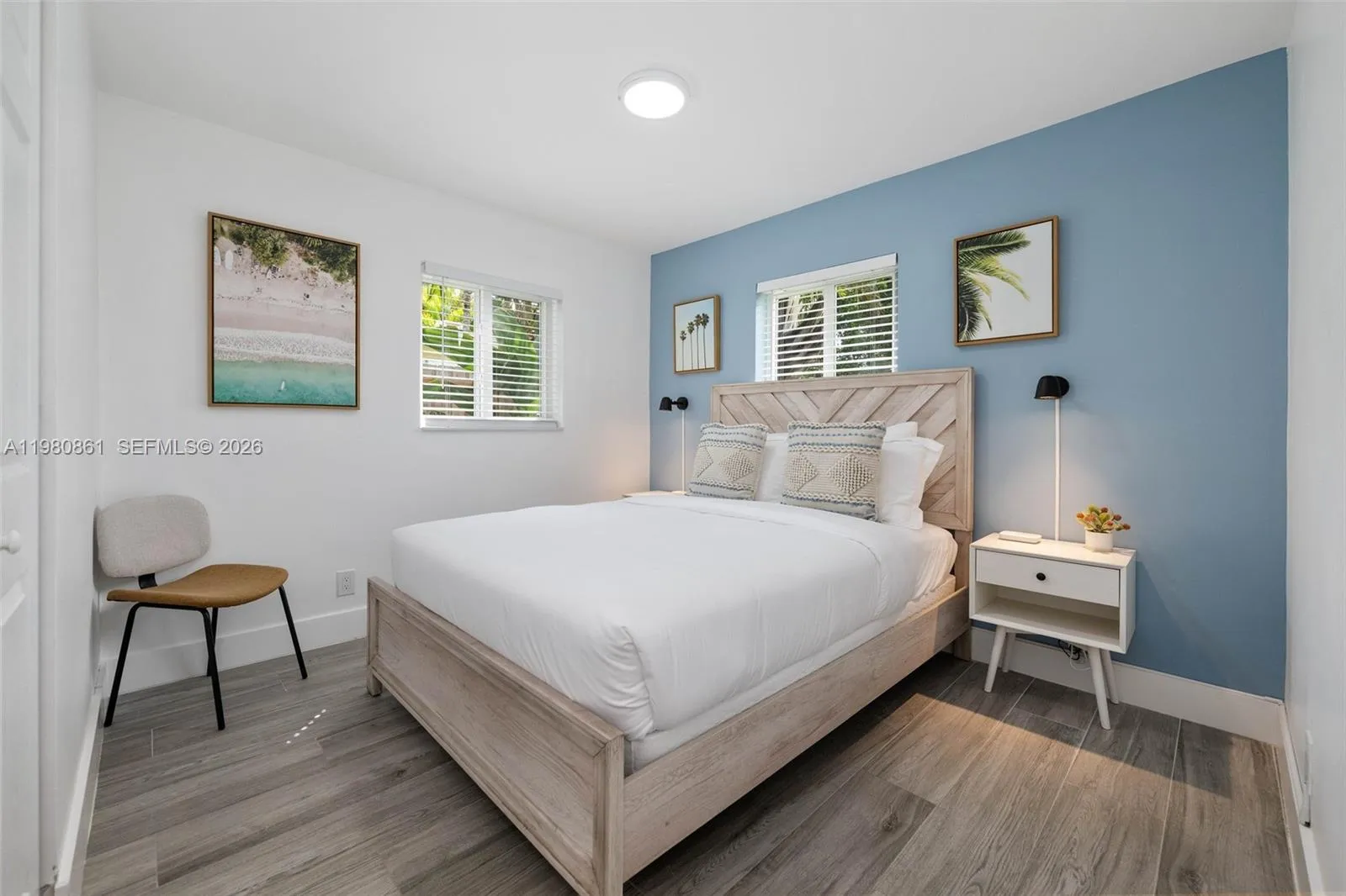 #3. An elegantly appointed bedroom retreat featuring designer finishes, a soothing accent wall, and wide-plank flooring—where refined comfort meets timeless sophistication.