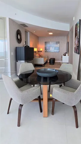 Neutral-toned wall covering, clean-lined structural ceiling detail, and large-format tile flooring