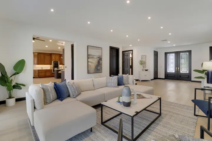 living room seeing kitchen and front doo
