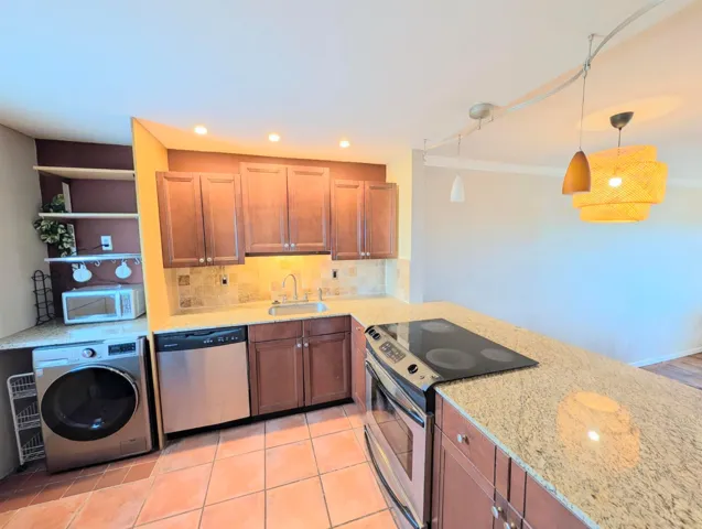Open Kitchen with counter bar, granite counters, stainless steel appliances.