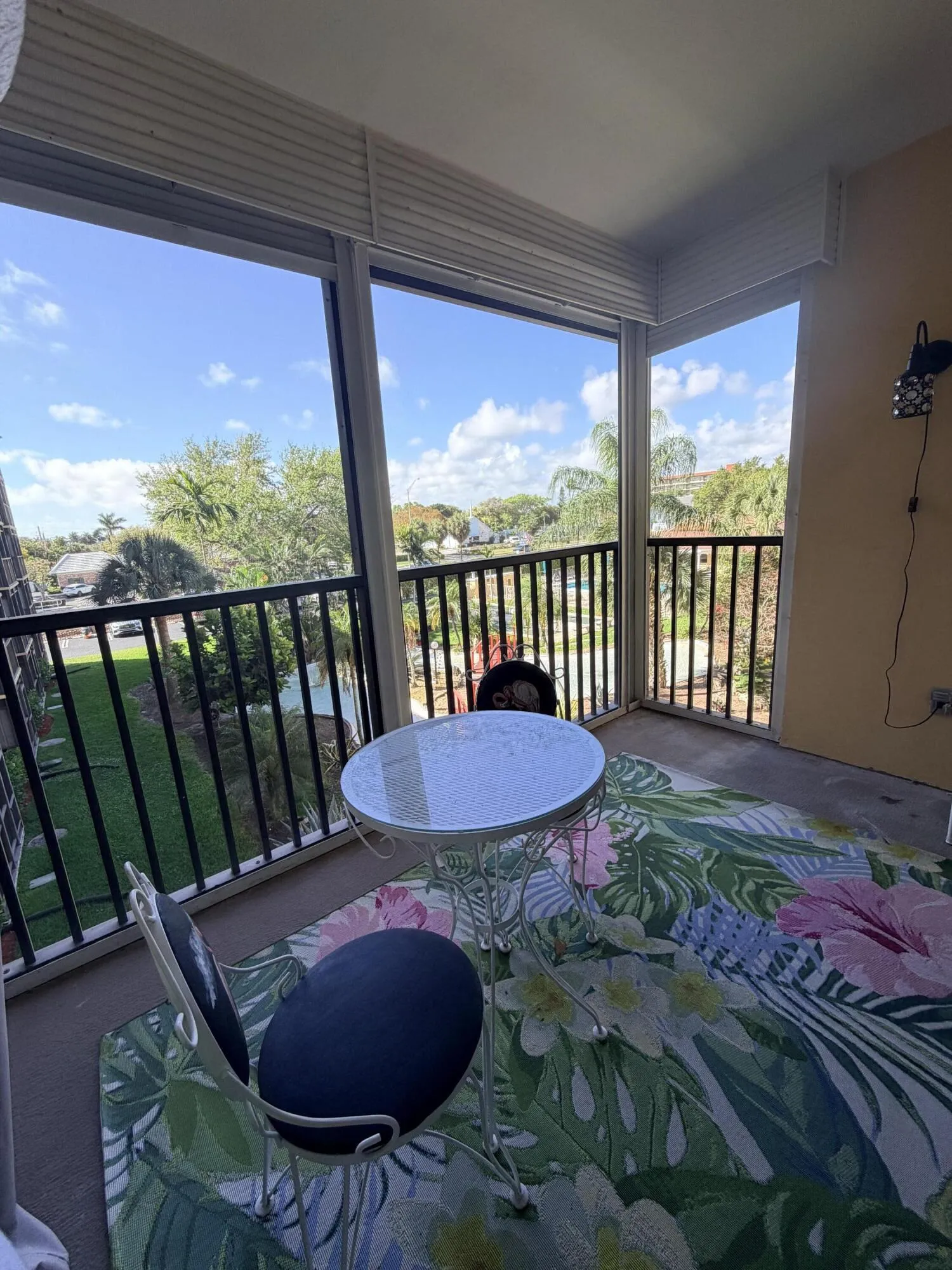 private screened balcony overlooking gardens, pond, and pool area