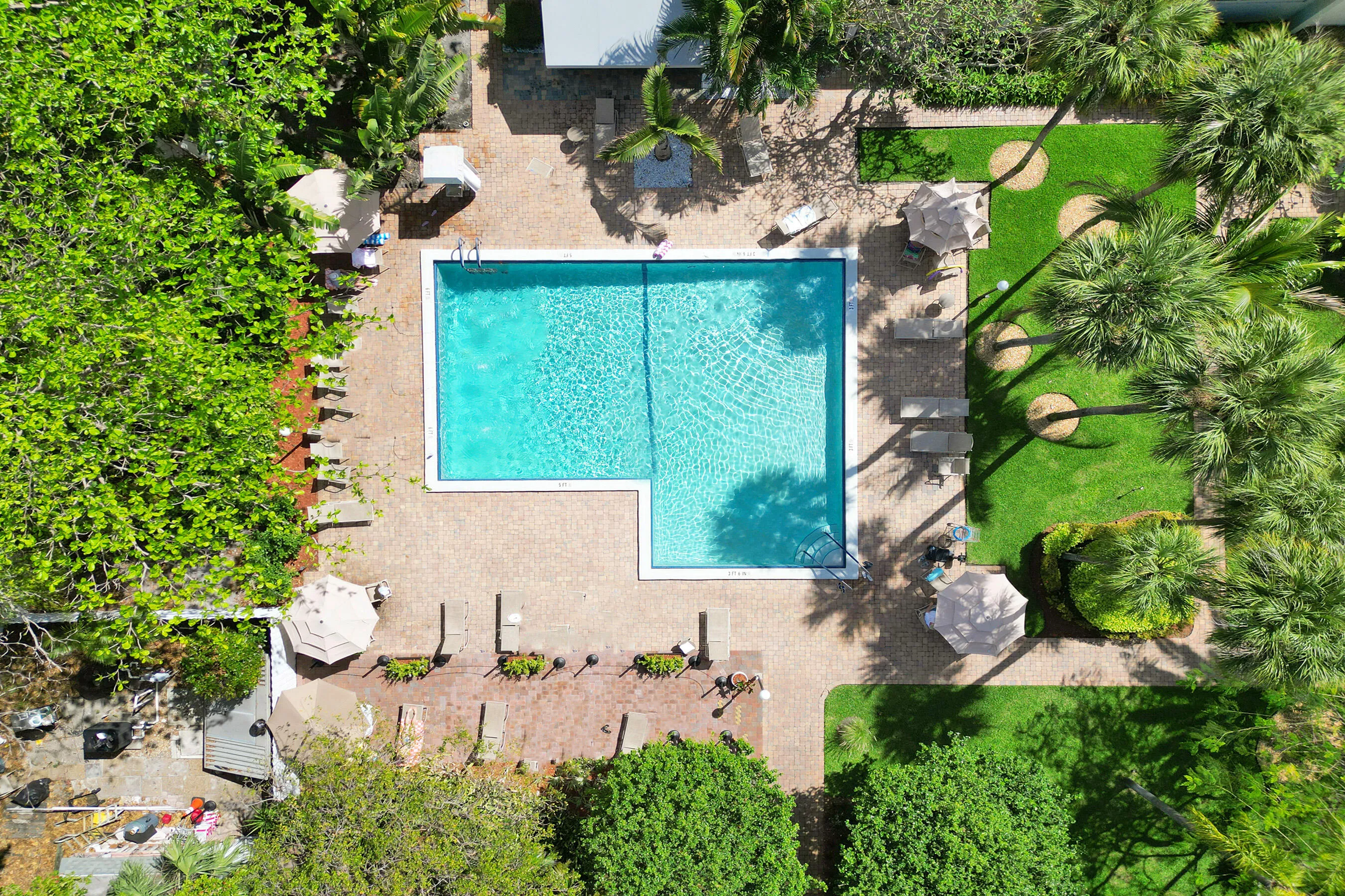 Pool area with tables, lounges and plenty or room for barbecue as well.