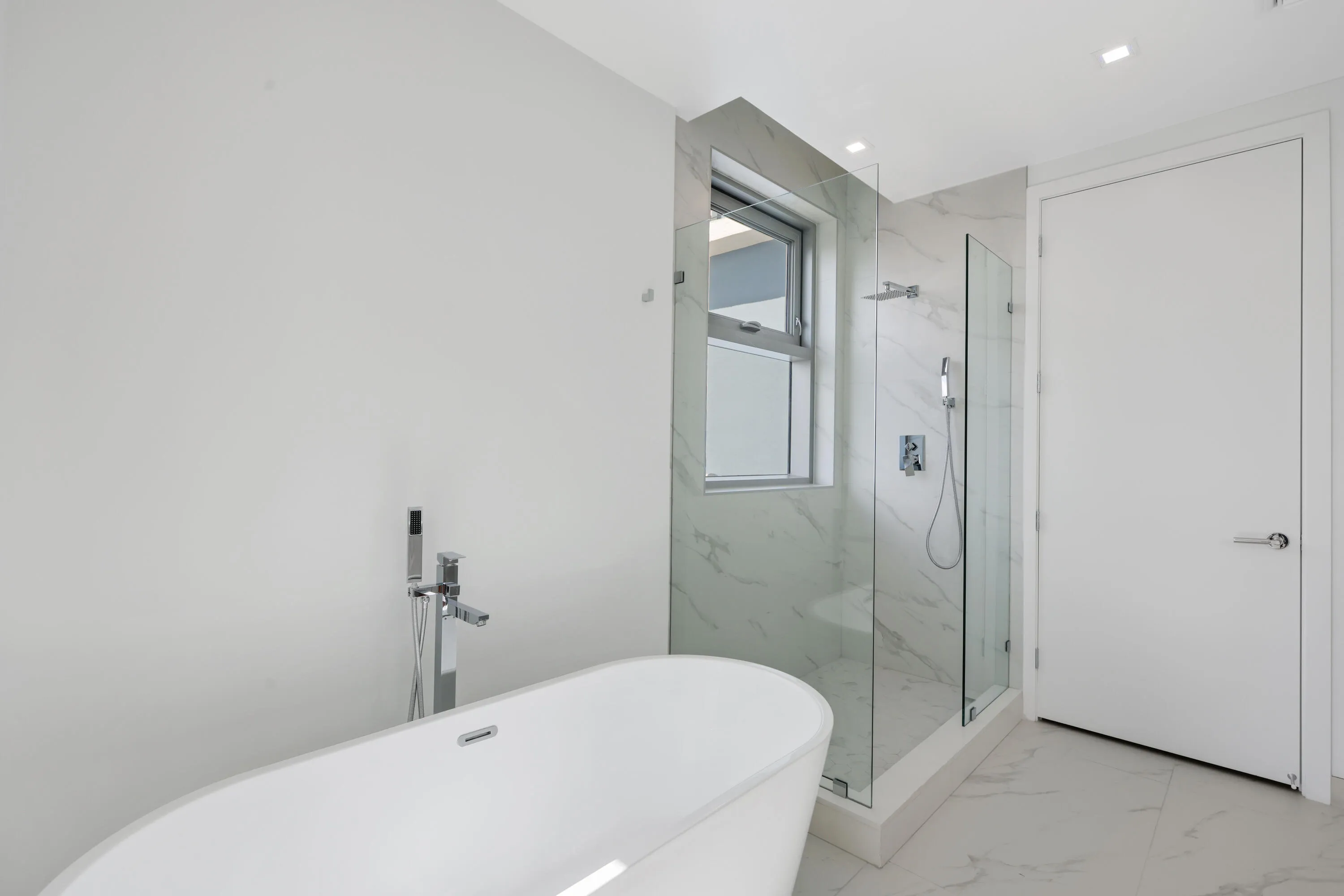 primary suite tub and shower with door entrance to private toilet