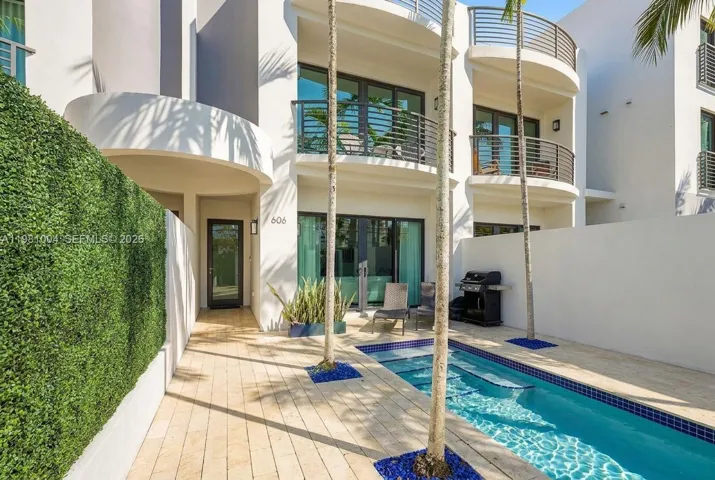 private gated courtyard entry, lush landscaping, sparkling pool