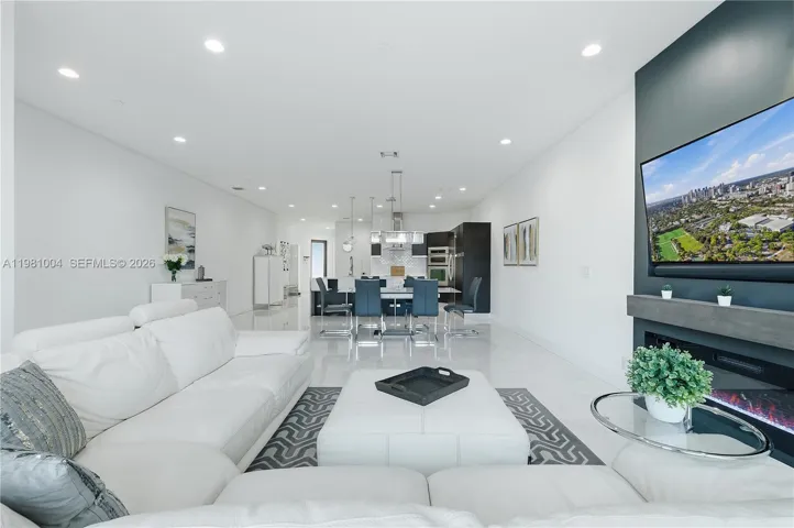 open living room, sliding glass doors to the pool, electric fireplace