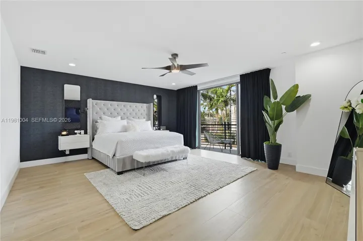 spacious primary suite with wallpaper and paneled walls, black out curtains, over looking pool, beautiful light wood-look tile