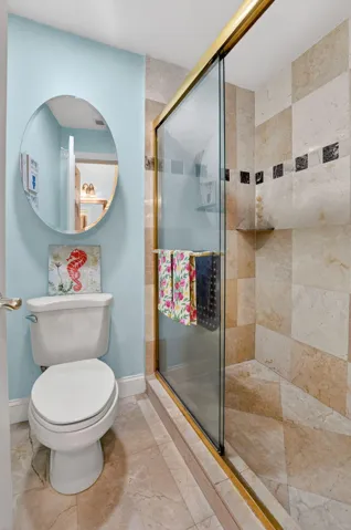Stall shower features upgaded tile to the ceiling with pretty inlays.