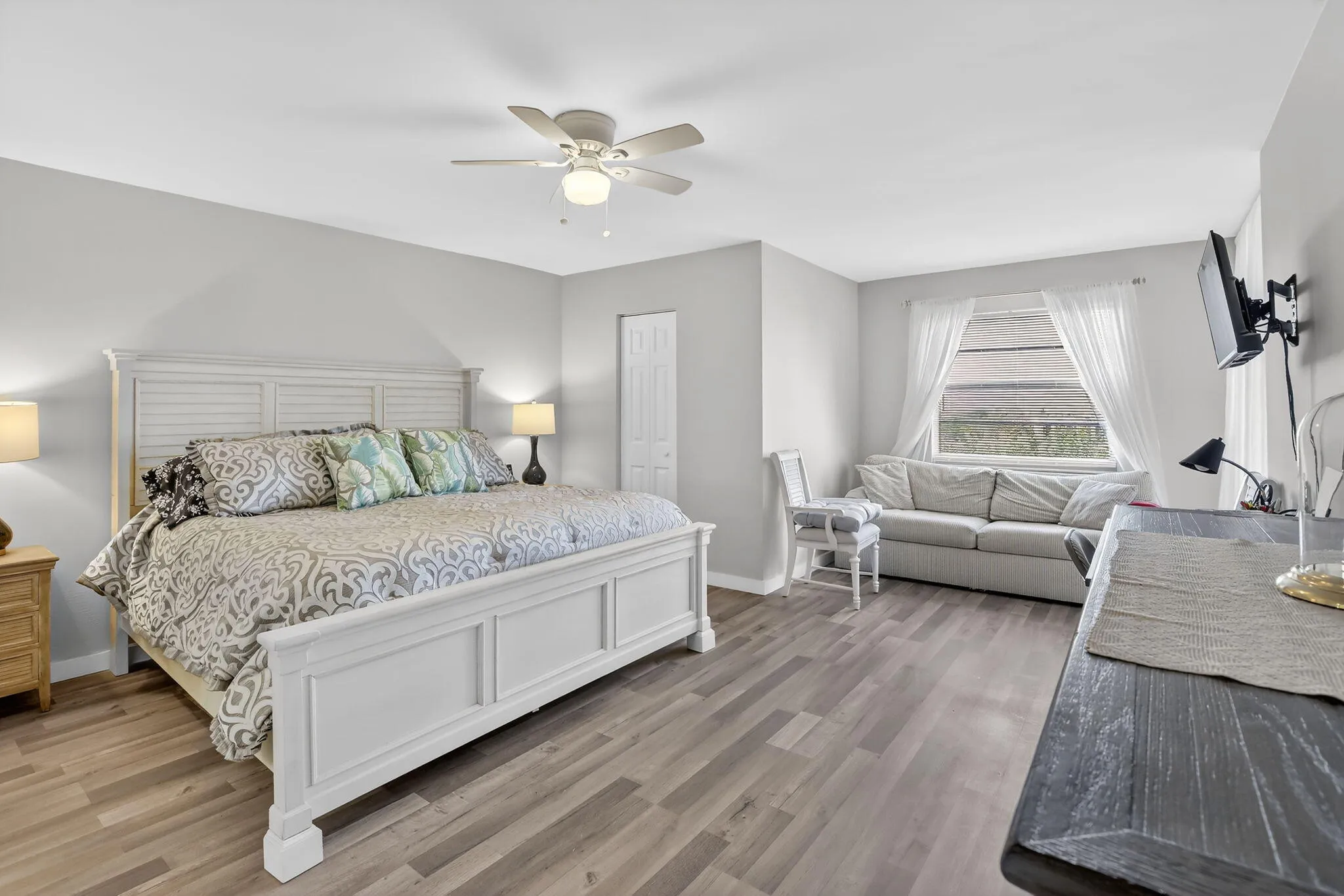 Primary bedroom is light and bright, featuring a large window as well as a sliding glass door unto the patio!