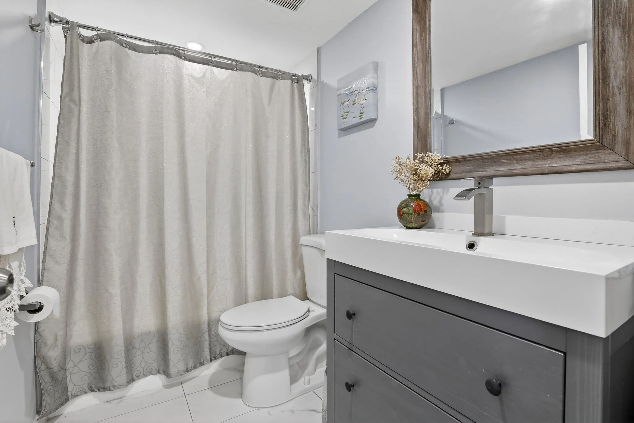Renovated guest bath features tub/shower combo and modern vanity!