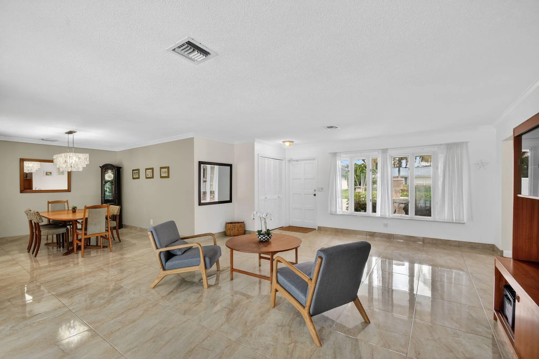 Bright living area featuring multiple windows and sliding glass doors allowing natural light throughout the space.