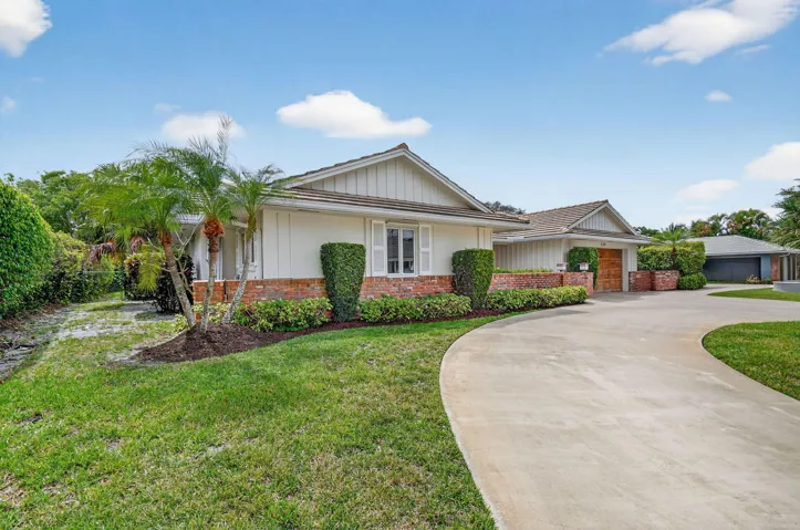 Front elevation showing single story design, landscaped yard, and extended driveway approach.