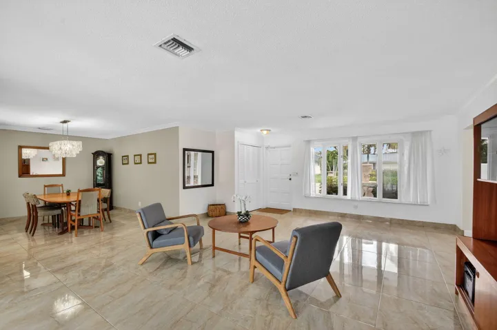 Bright living area featuring multiple windows and sliding glass doors allowing natural light throughout the space.