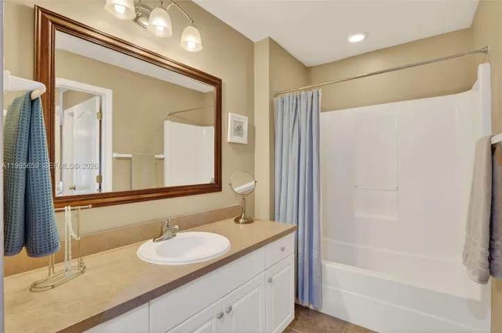 Spacious primary bathroom with recessed lighting and light fixture