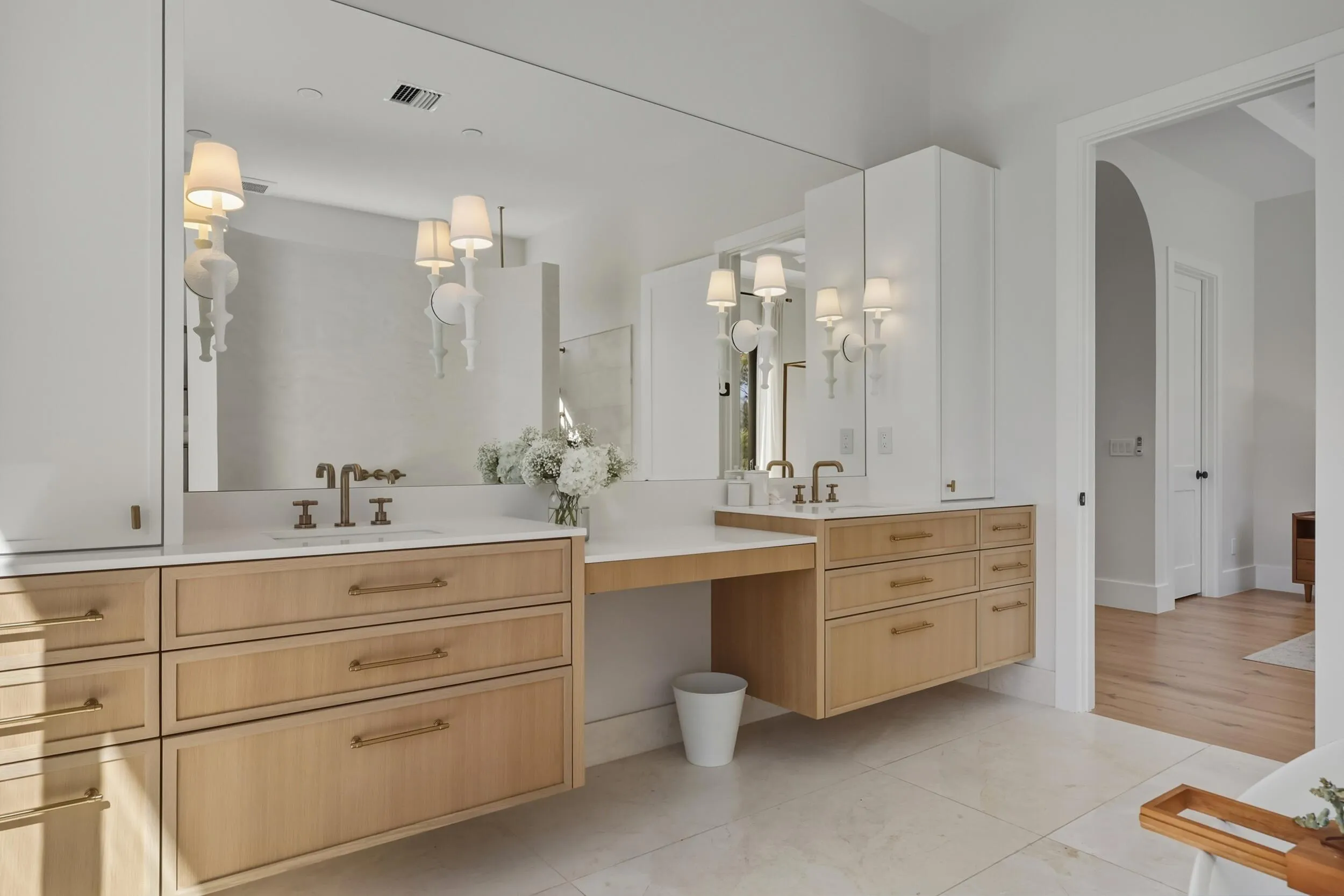 Rift cut white oak floating double vanity with quartz counters, plaster sconces, Brizo plumbing fixtures and storage towers
