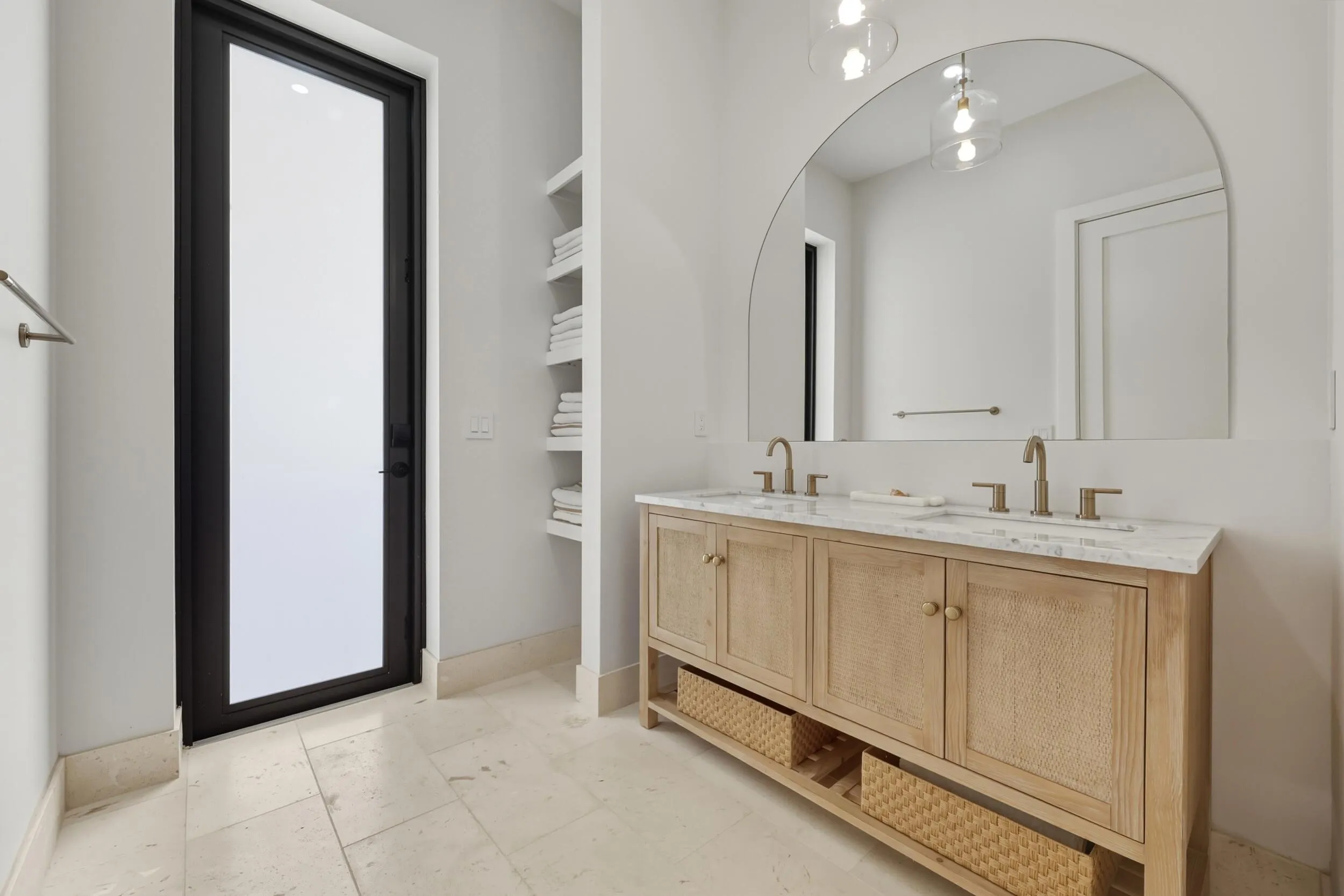 Cabana bath with travertine flooring, double sink, towel storage & custom mirror