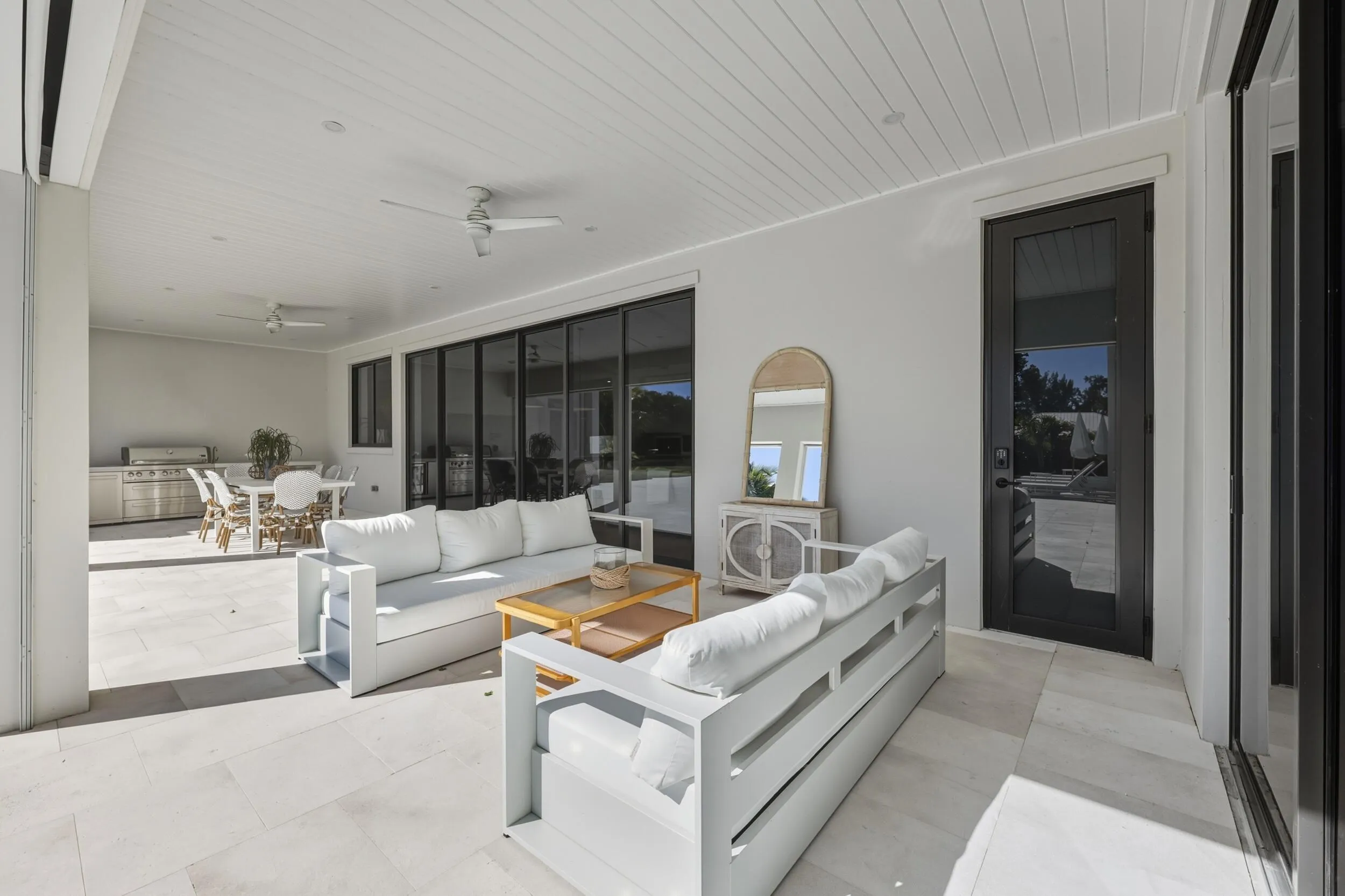 Covered Loggia with t&g ceiling detail, 2 fans & sand blaster marble tiles - door provides access to Cabana bath