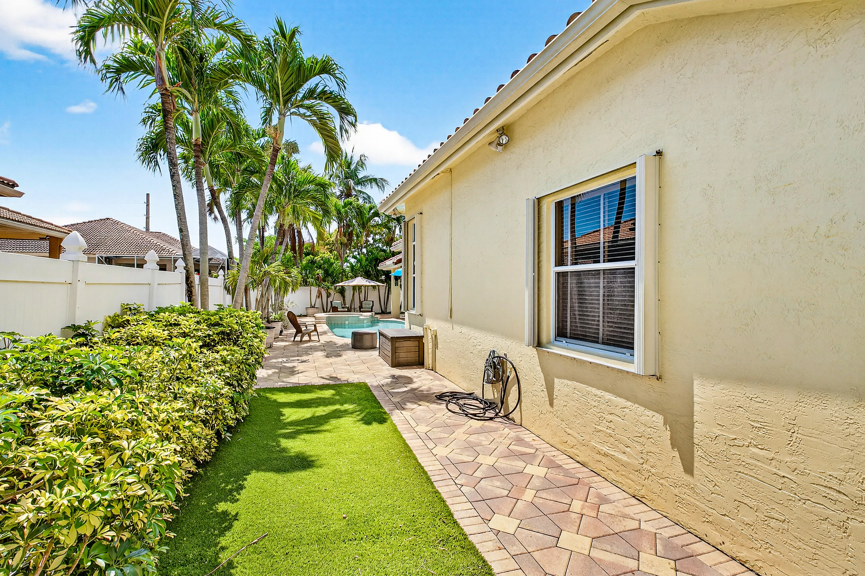 Spacious outdoor living area with pool, spa, and covered patio. Luxury Cypress Creek home featuring indoor and outdoor entertaining spaces. Backyard oasis in Cypress Creek with tropical landscaping, pool, spa, and multiple seating areas perfect for Florida living.