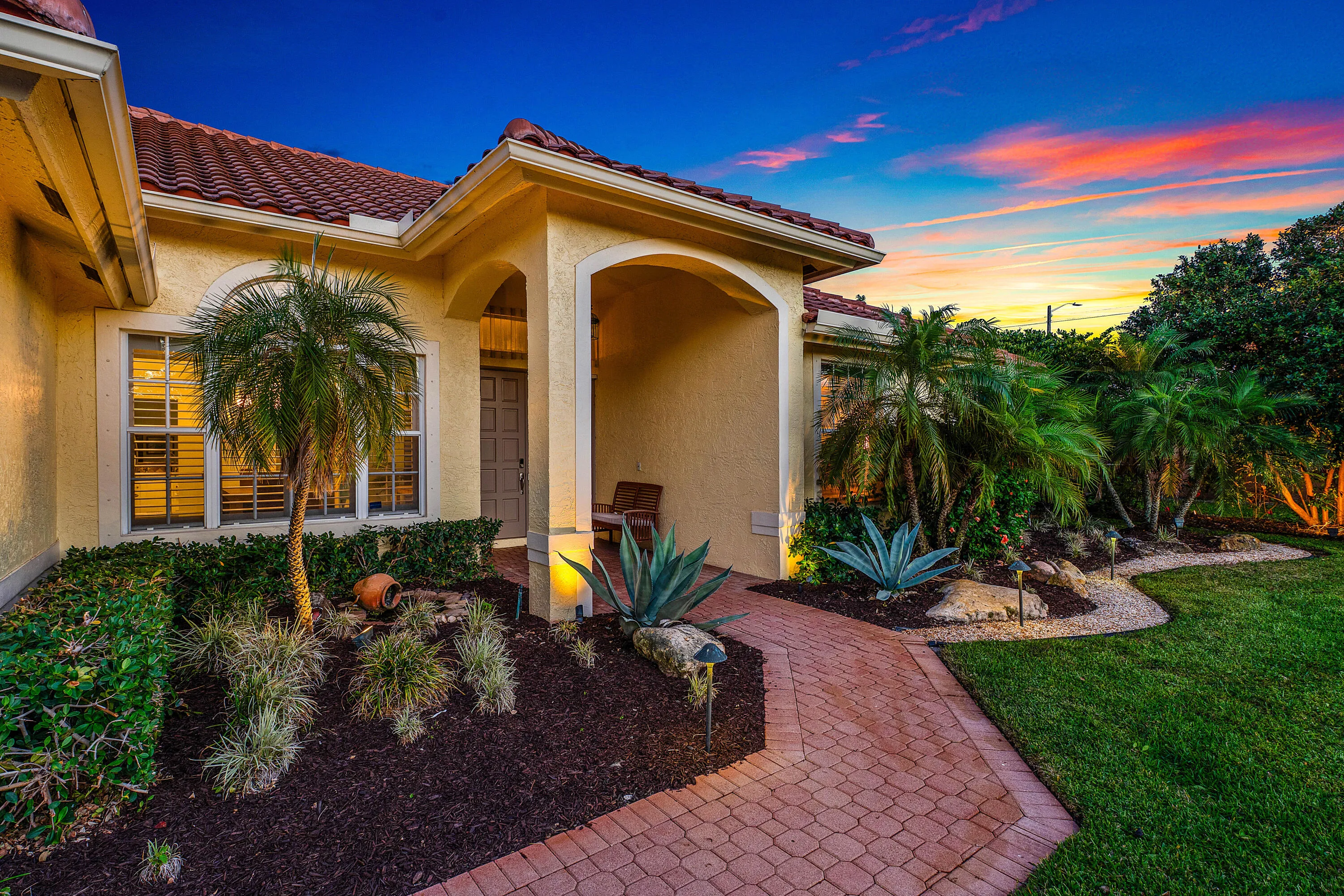 Stunning twilight view of this luxury Cypress Creek pool home featuring 4 bedrooms, 3 bathrooms, and a roof installed in October 2022. Beautiful evening exterior showcasing the resort-style atmosphere and exceptional curb appeal of this Boynton Beach residence.