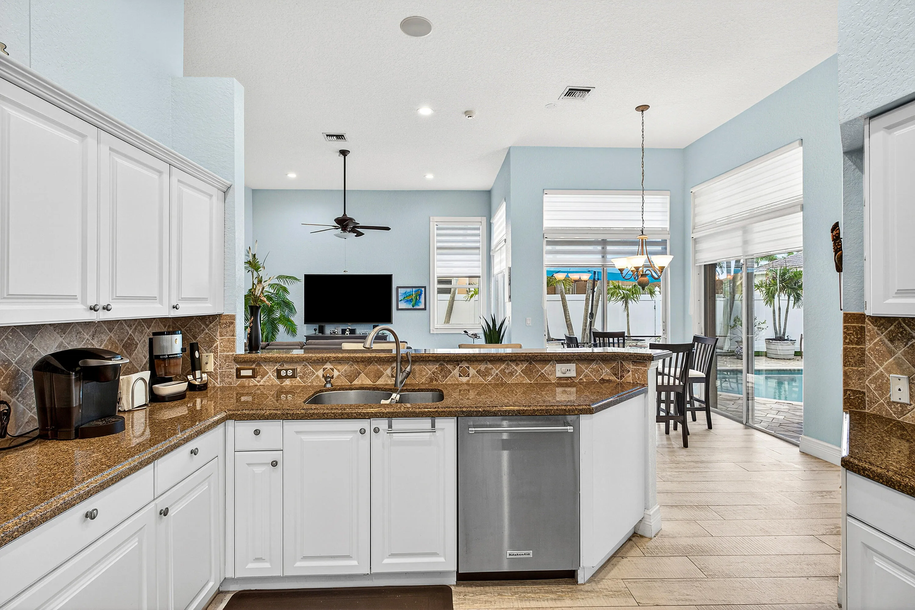 Updated kitchen featuring generous counter space, ample cabinetry, and views of the pool and patio. Spacious kitchen designed for entertaining with easy access to indoor and outdoor living areas.