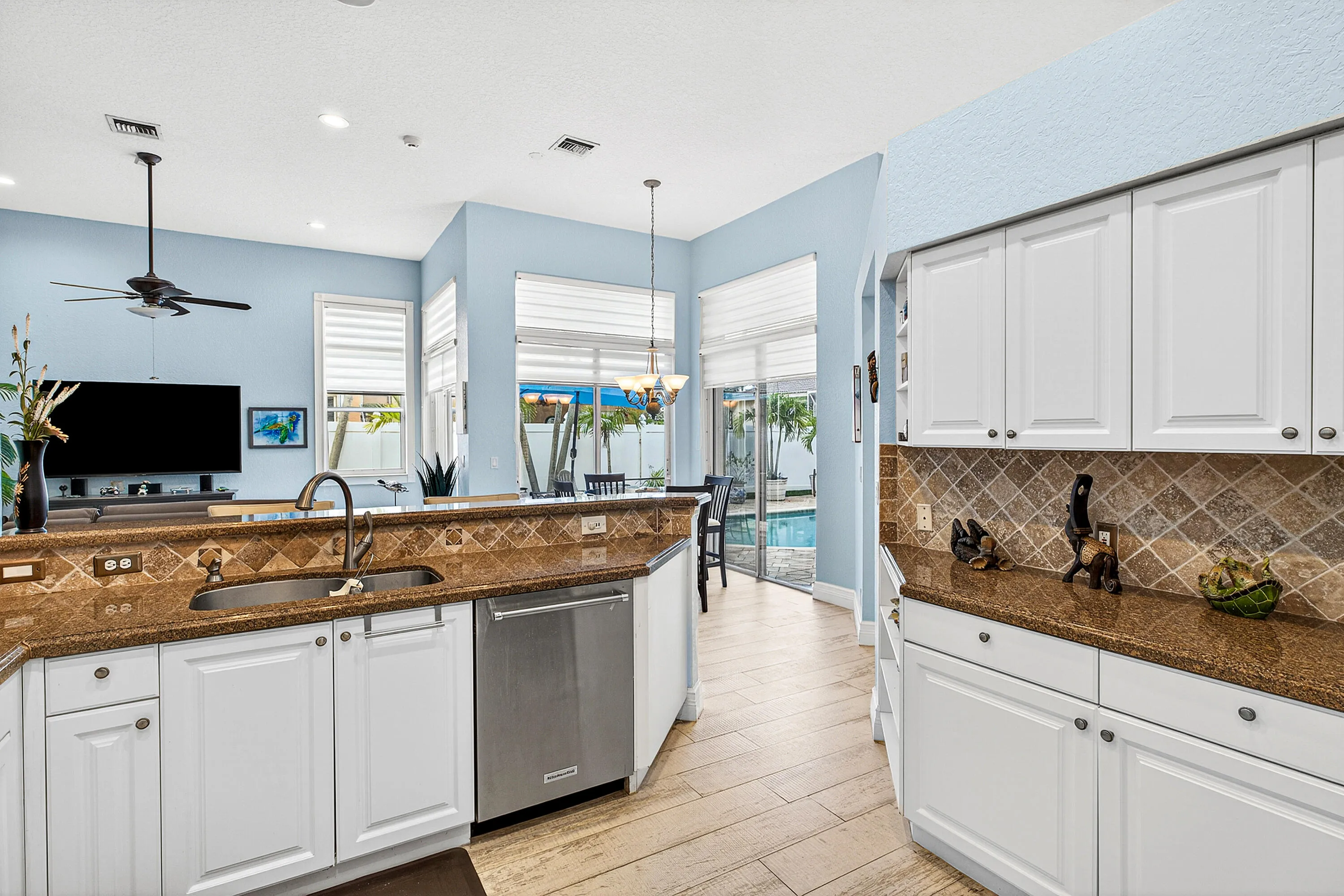 Updated kitchen featuring generous counter space, ample cabinetry, and views of the pool and patio. Spacious kitchen designed for entertaining with easy access to indoor and outdoor living areas.