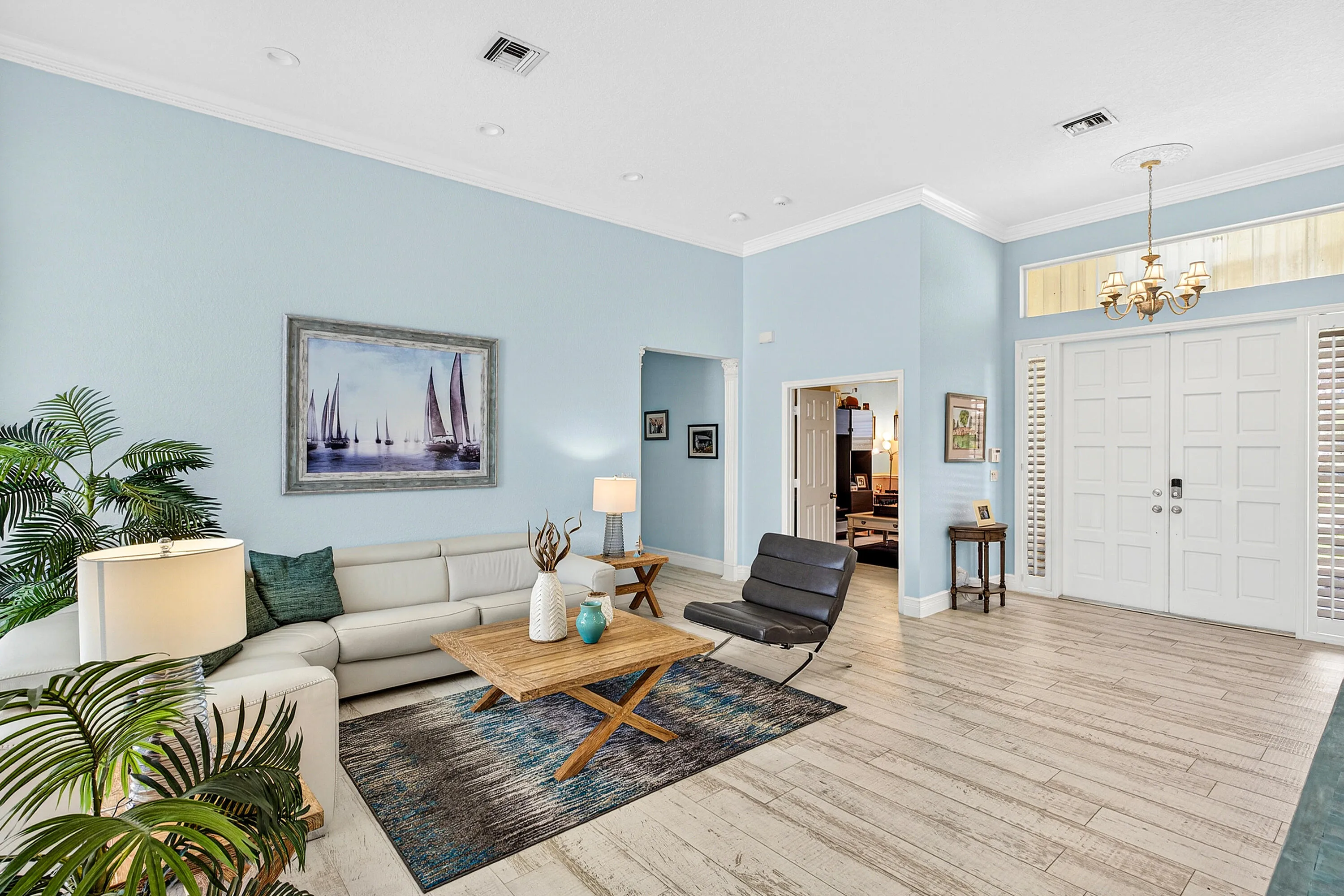 Spacious living room with abundant natural light and views of the outdoor living area and pool. Open-concept living space designed for comfort, entertaining, and everyday luxury living in Cypress Creek.