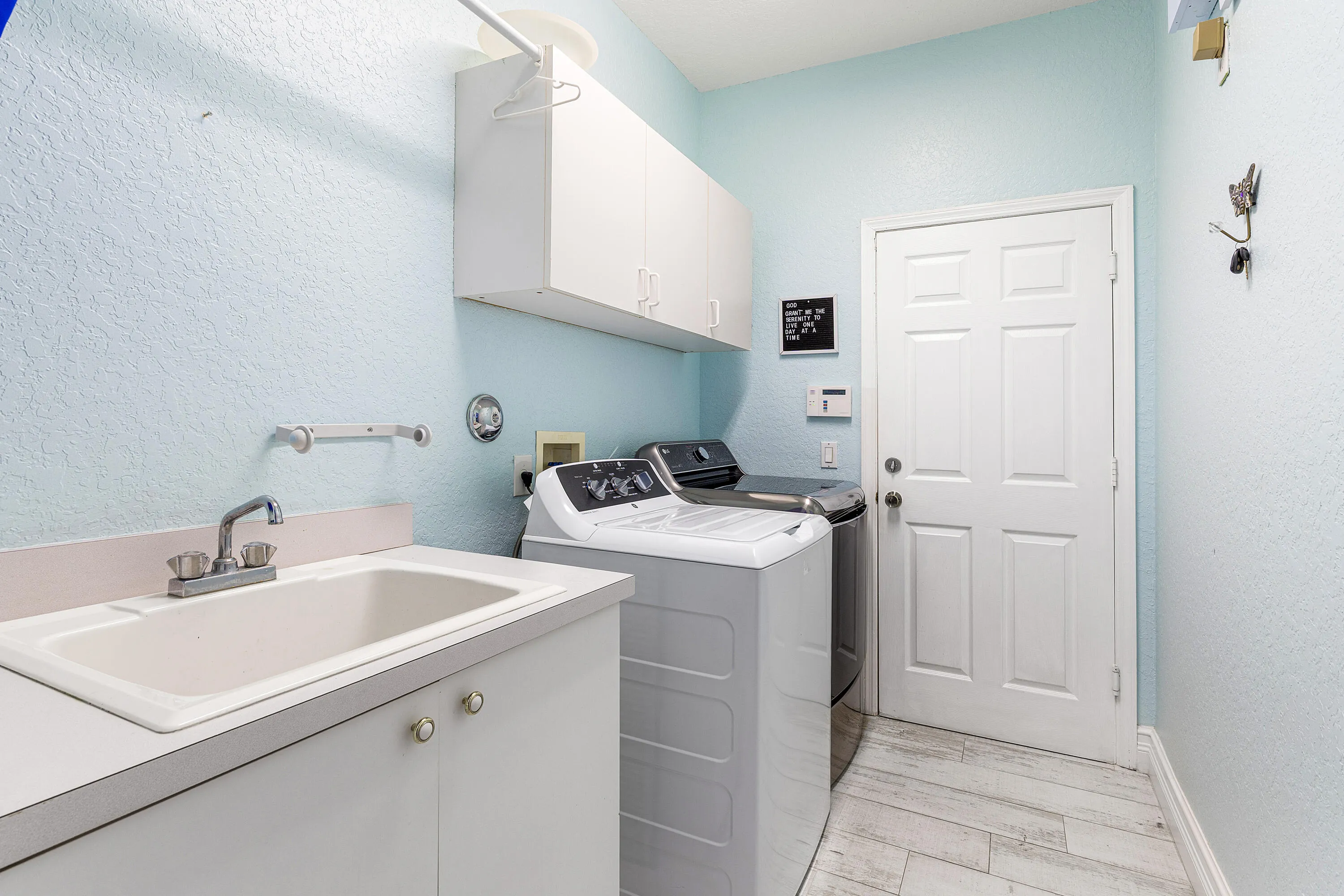 Dedicated laundry room with additional storage space and convenient access, designed to make everyday living easy in this luxury Cypress Creek home.