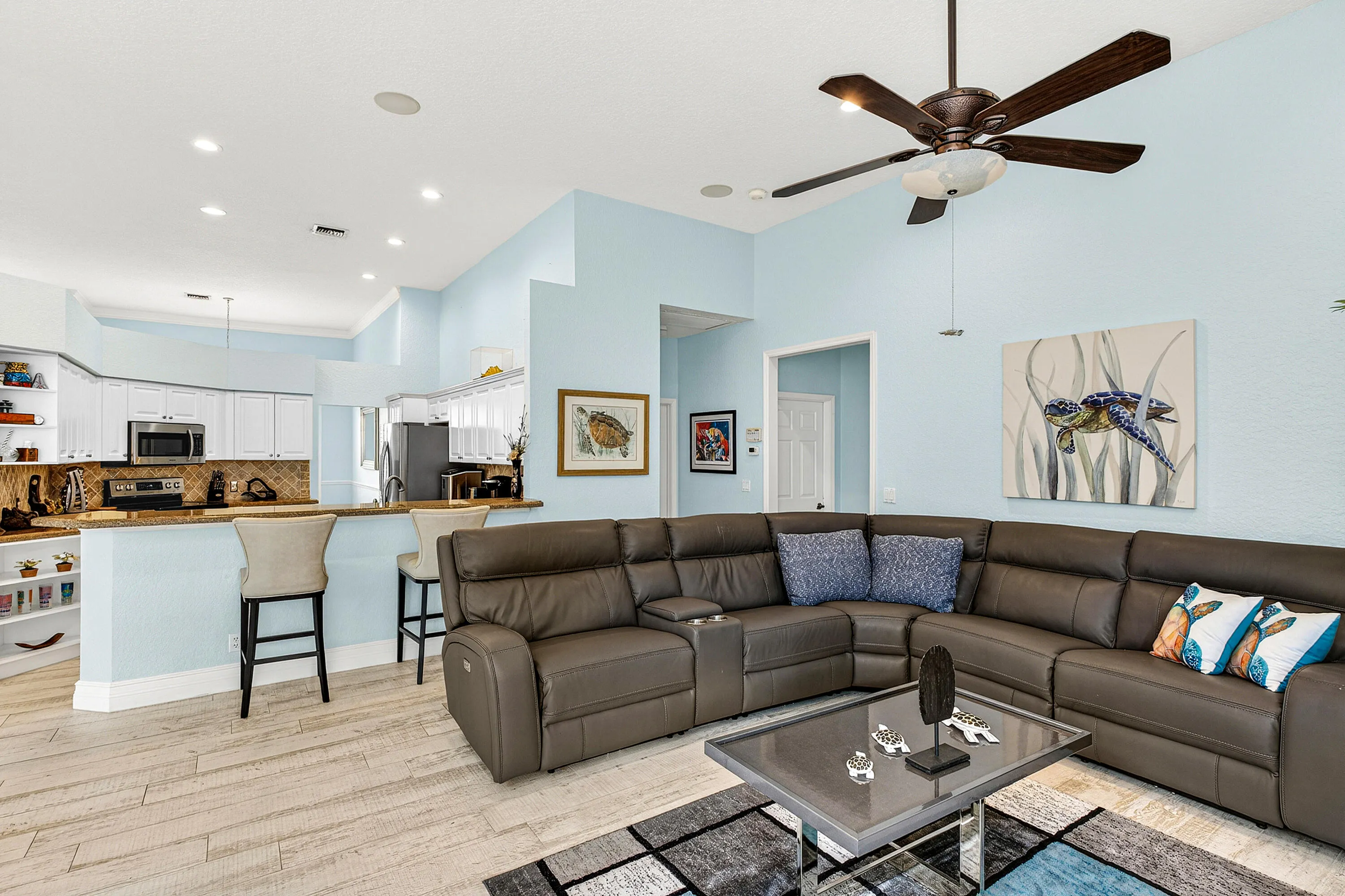 Comfortable family room offering an open layout and seamless connection to the kitchen and outdoor spaces. Large gathering area perfect for relaxing while enjoying views of the tropical backyard.
