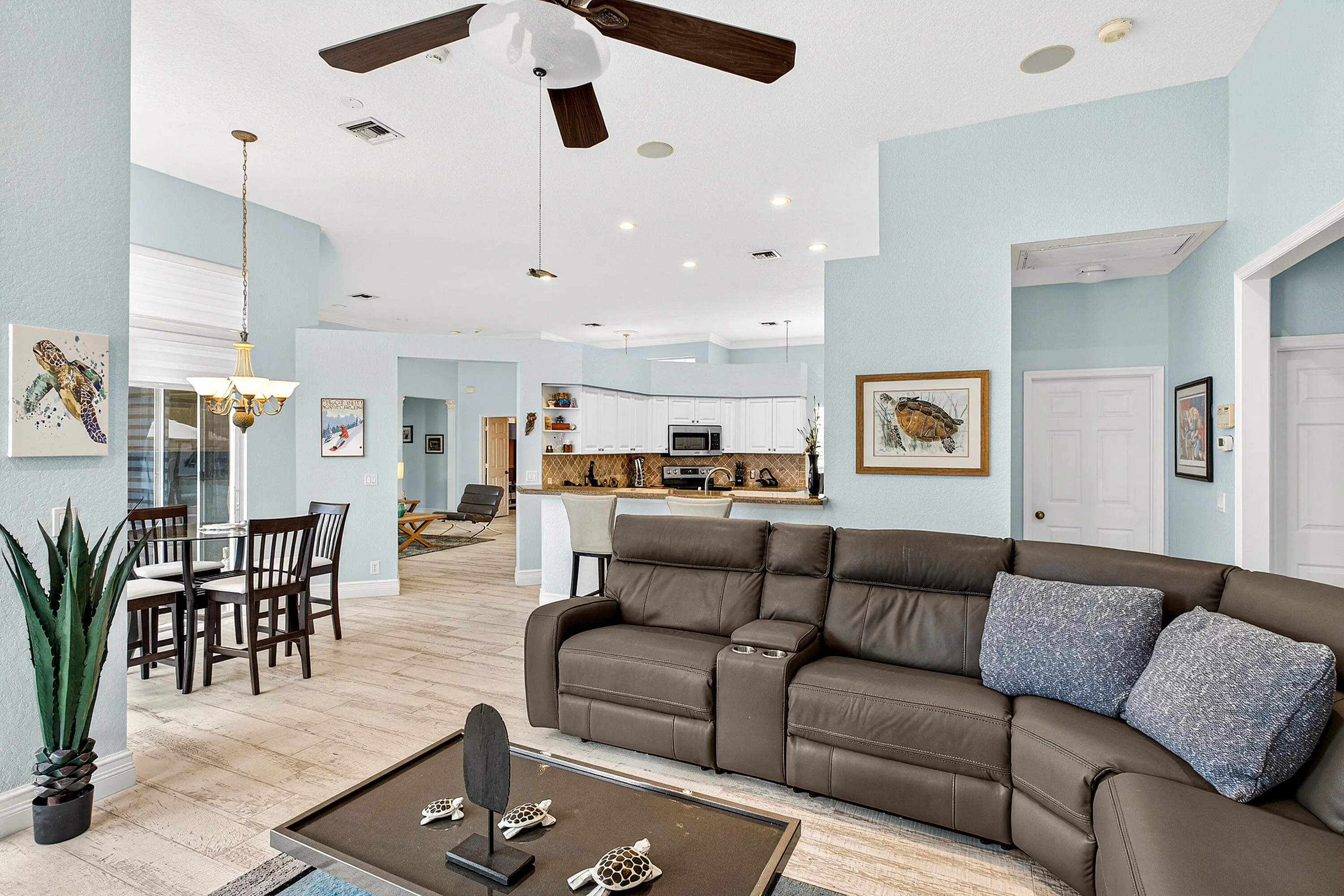Comfortable family room offering an open layout and seamless connection to the kitchen and outdoor spaces. Large gathering area perfect for relaxing while enjoying views of the tropical backyard.