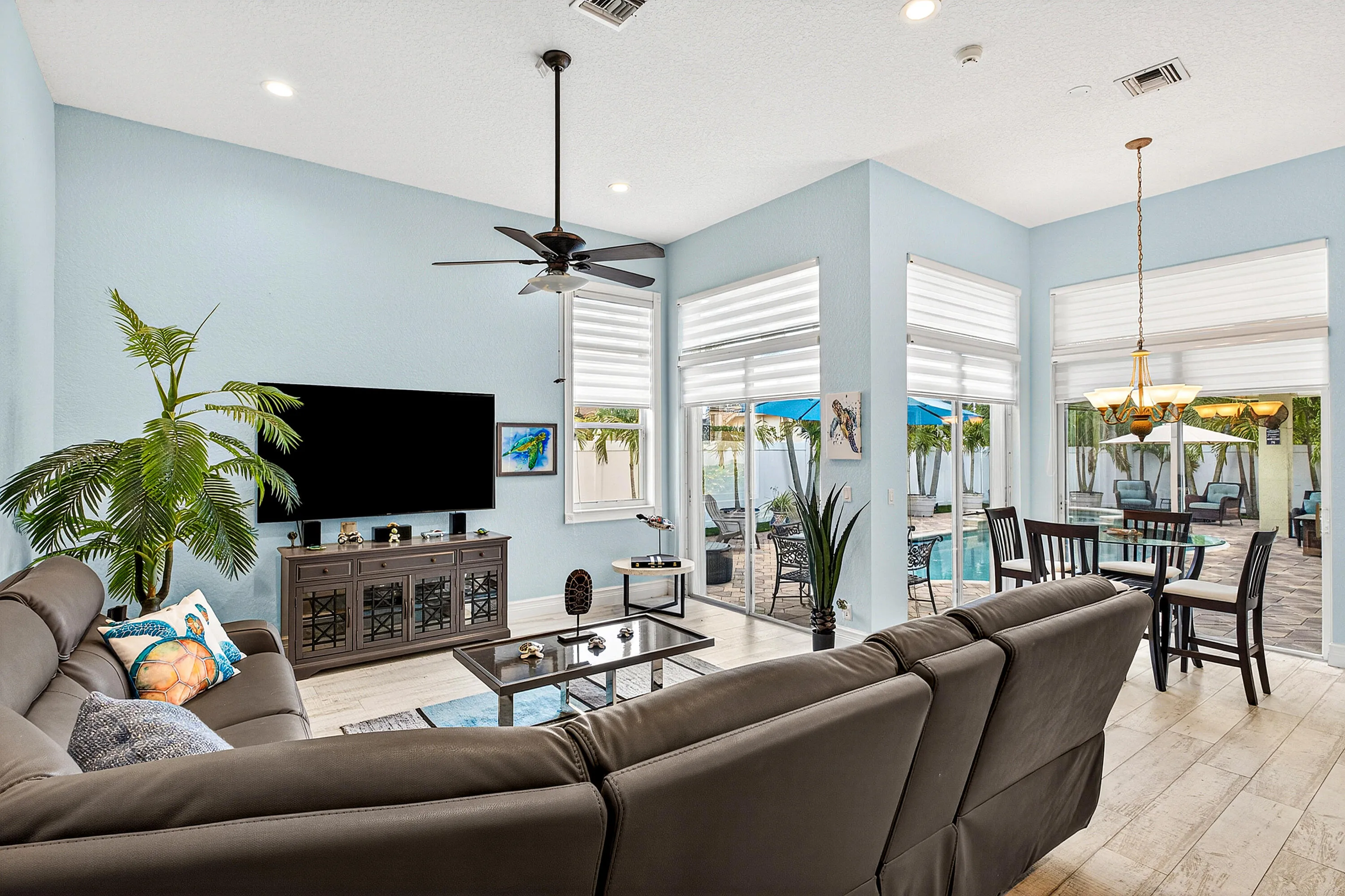 Spacious living room with abundant natural light and views of the outdoor living area and pool. Open-concept living space designed for comfort, entertaining, and everyday luxury living in Cypress Creek.
