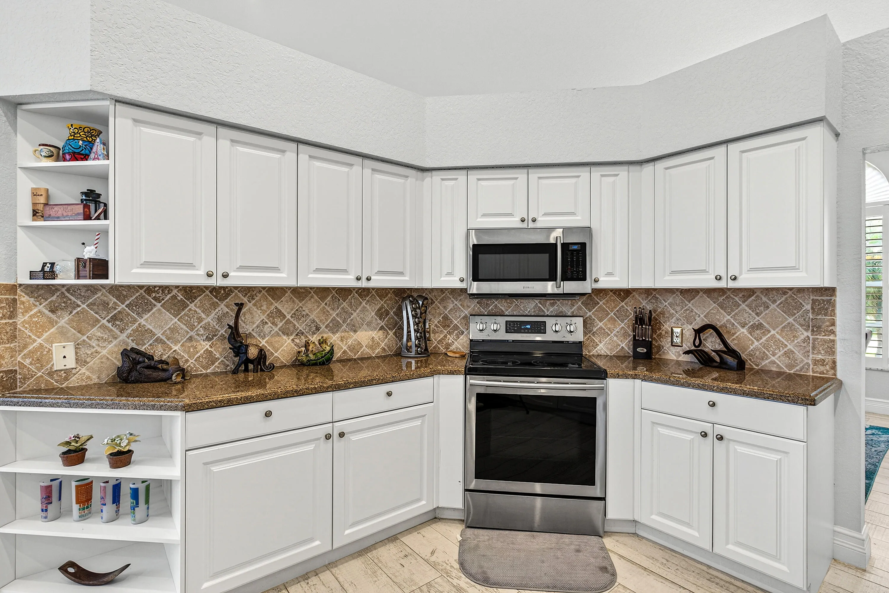 Updated kitchen featuring generous counter space, ample cabinetry, and views of the pool and patio. Spacious kitchen designed for entertaining with easy access to indoor and outdoor living areas.