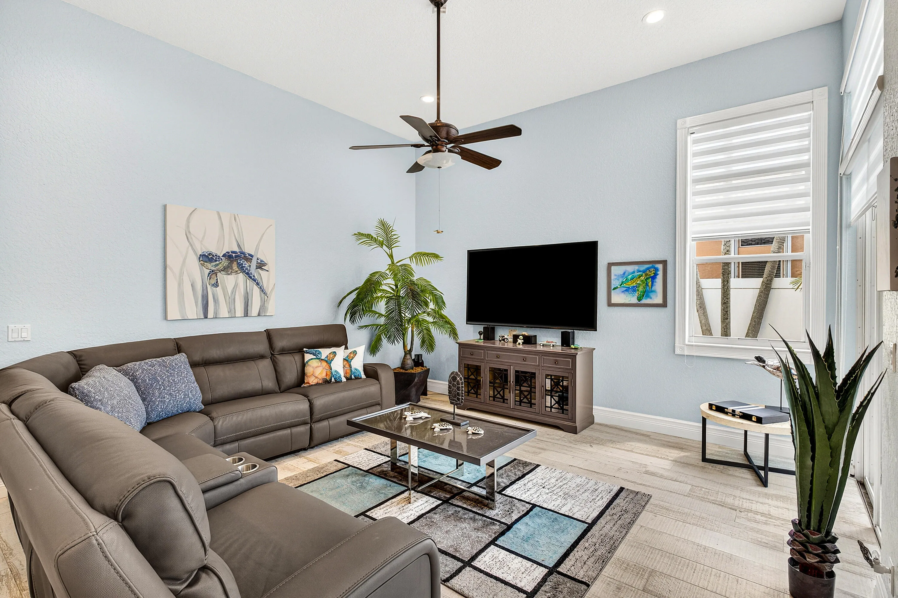 Spacious living room with abundant natural light and views of the outdoor living area and pool. Open-concept living space designed for comfort, entertaining, and everyday luxury living in Cypress Creek.