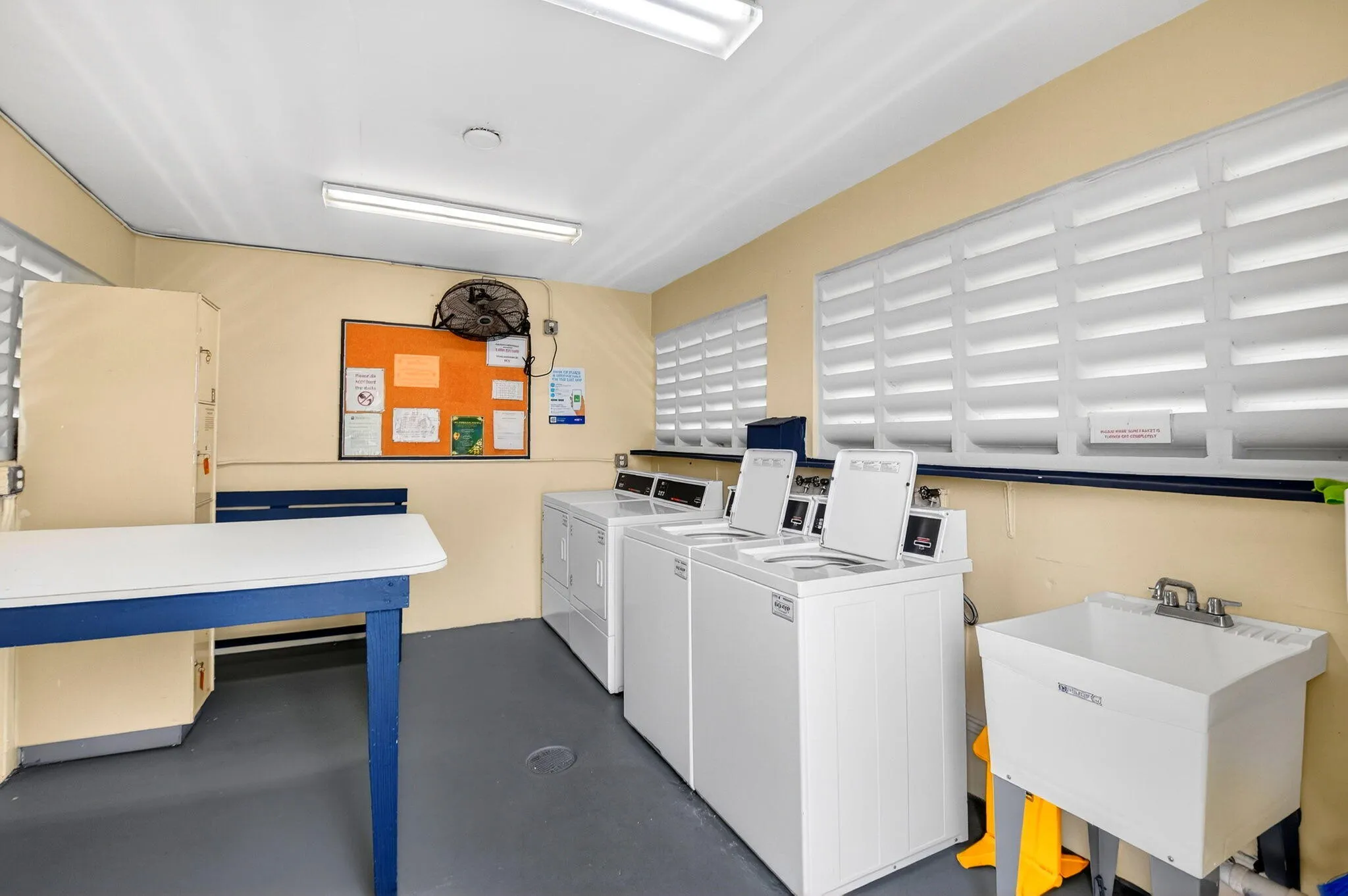 Clean, well-maintained space with washer, dryers, & utility sink.