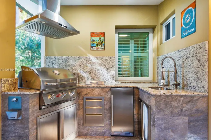 EXTERIOR BACK PATIO WITH BUILT IN BARBECUE AND HALF BATHROOM