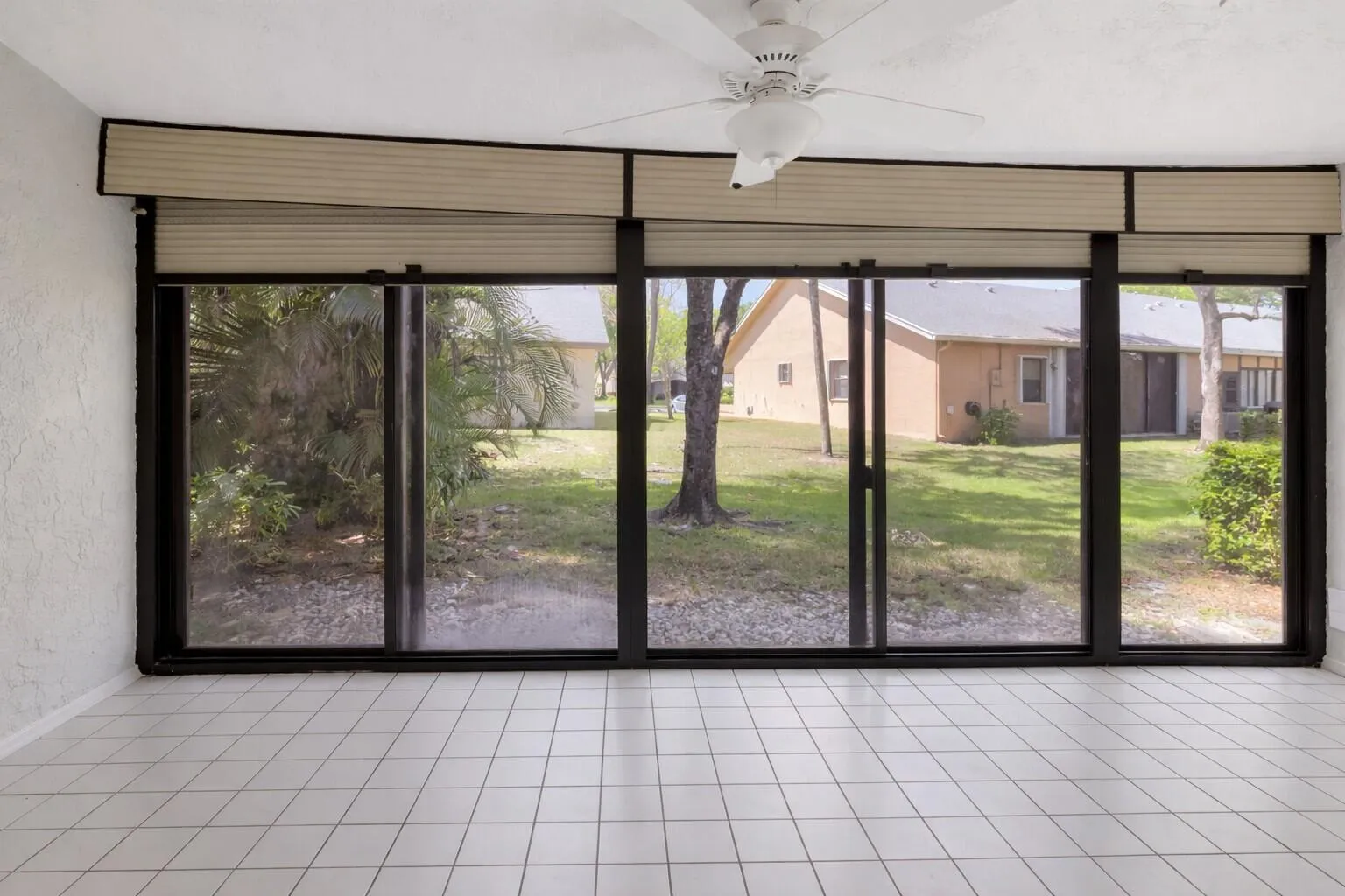 Spacious tiled room with wall of windows & natural light.