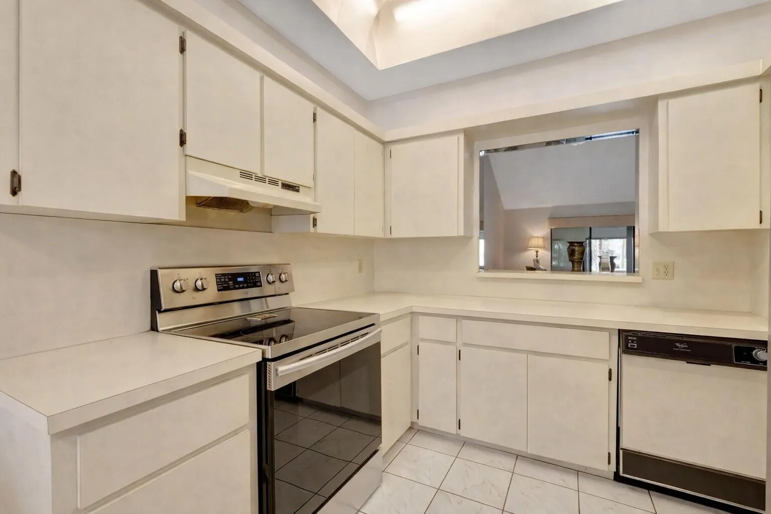 Clean kitchen with ample cabinetry & pass through opening.