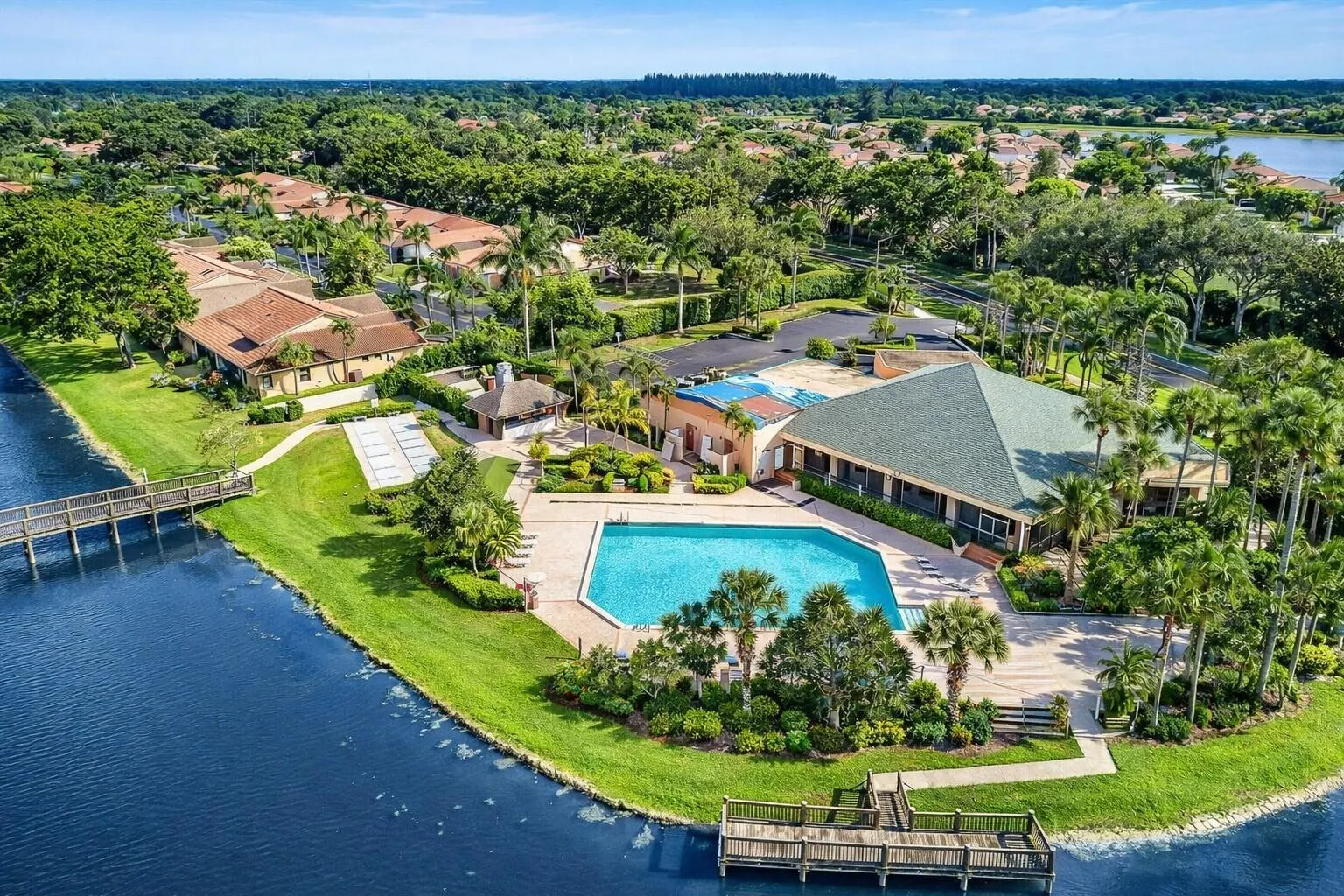 Beautiful community pool & clubhouse surrounded by lush landscaping.