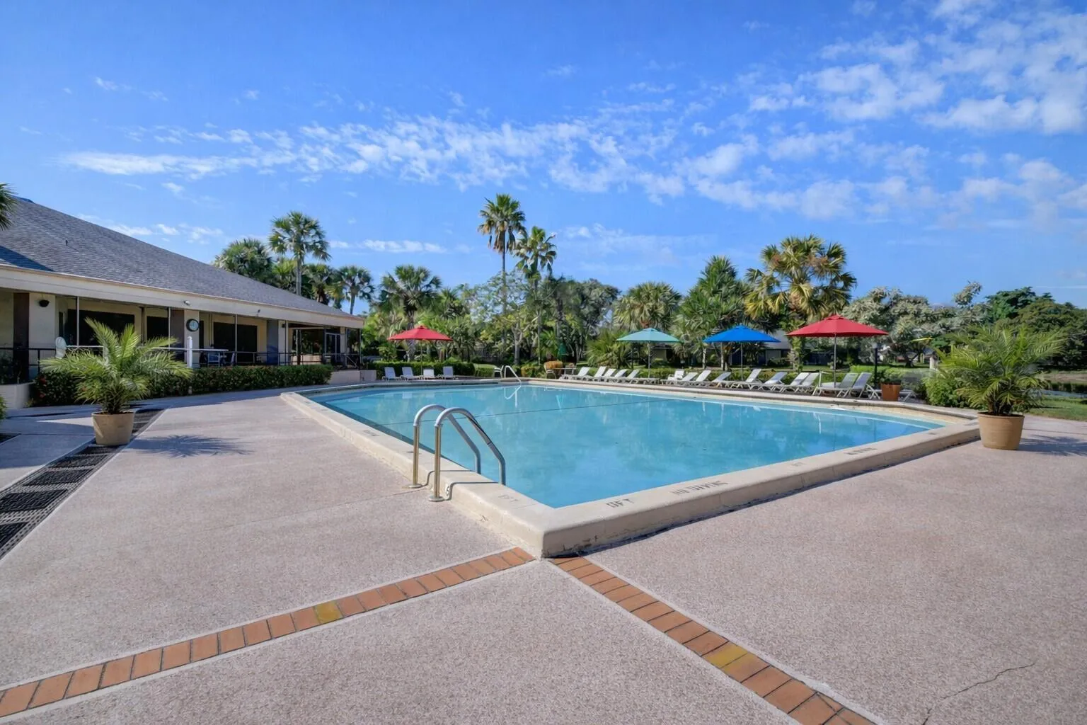 Relaxing pool area with lounge seating & lush landscaping.