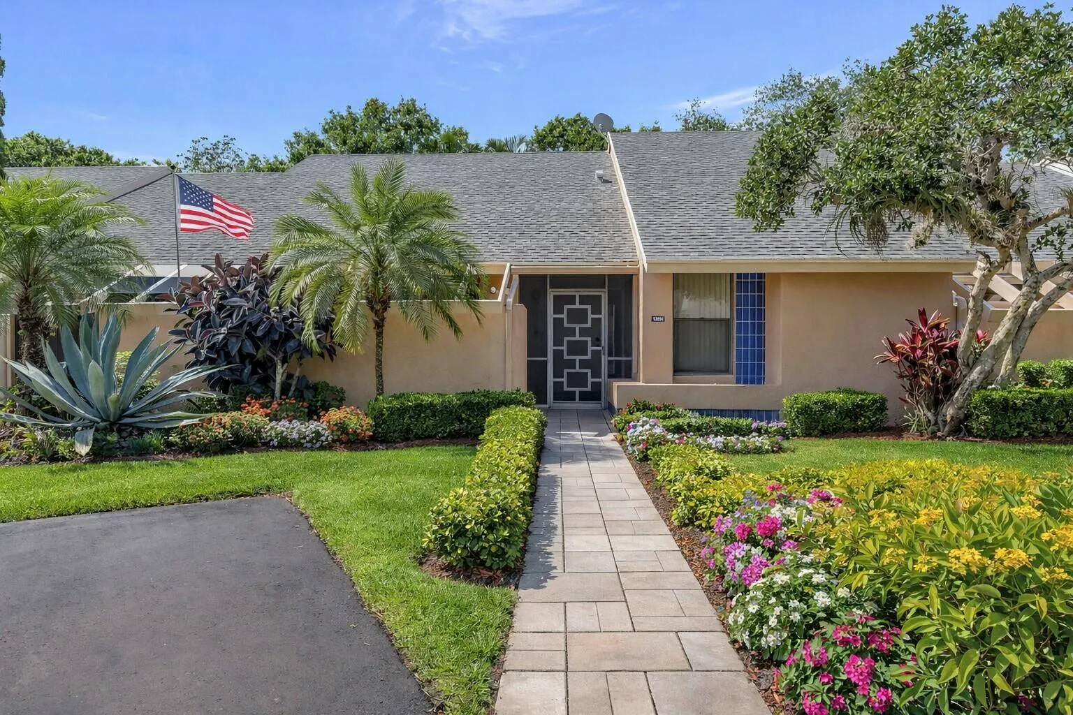 Beautifully maintained walkway with colorful landscaping and curb appeal.