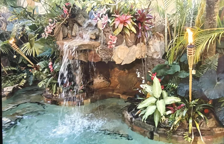 Waterfall pool led lit with tiki torches