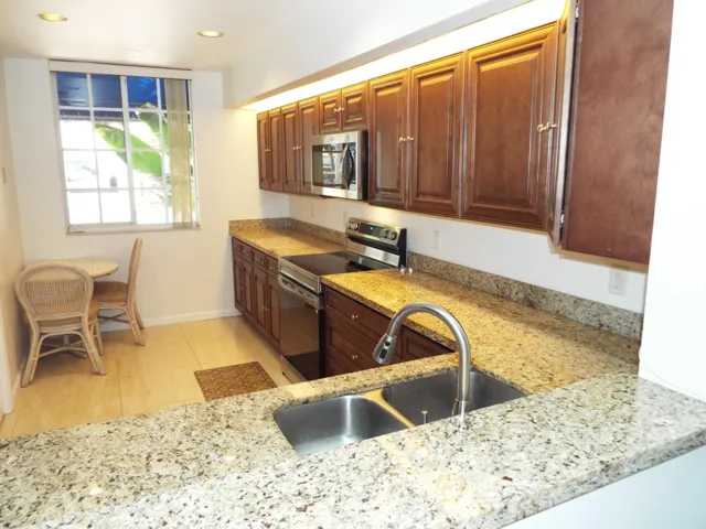 Updated kitchen with wood cabinets and grant counter tops stainless steel appliance