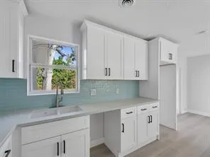 kitchen cabinets, sink, countertops and backsplash